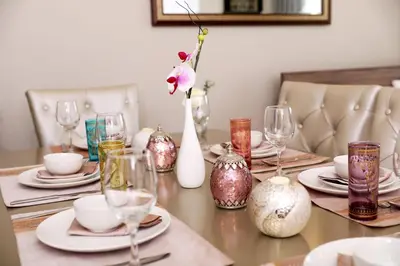 a dining room table with vases and glasses on it at Luxury Casa - Grand Sea View Apartment JBR Beach 2BR in Dubai