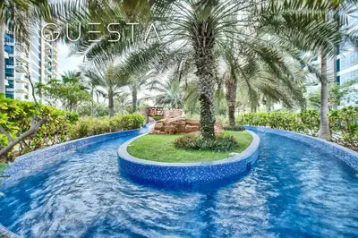 a swimming pool with a palm tree in a resort at Oceana Residences, Free beach & pool access in Dubai