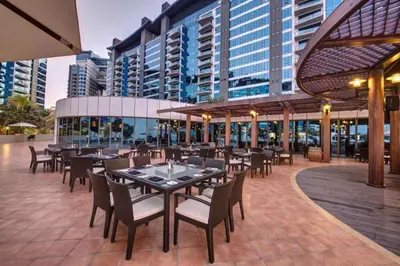 a restaurant with tables and chairs and buildings at Oceana Residences, Free beach & pool access in Dubai