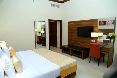 a hotel room with a bed and a desk and a television at Tulip Al Barsha Hotel Apartment in Dubai