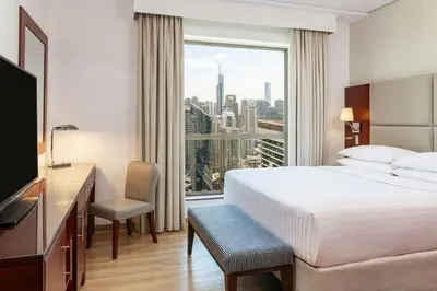 a hotel room with a bed and a desk and a window at Sheraton The Walk, Dubai in Dubai