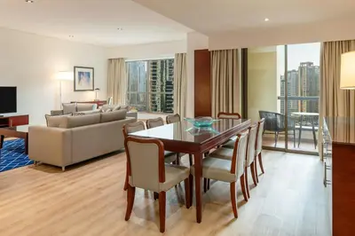a living room with a dining table and a couch at Sheraton The Walk, Dubai in Dubai