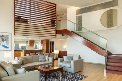 a living room with couches and a staircase at Sheraton The Walk, Dubai in Dubai