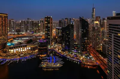 a city skyline at night with boats in the water at Sheraton The Walk, Dubai in Dubai