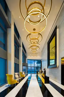 a lobby with a large chandelier in a building at Millennium Atria Business Bay in Dubai