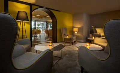a waiting room with chairs and tables and a mirror at Millennium Atria Business Bay in Dubai