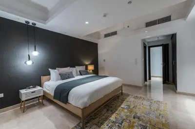 a bedroom with a large bed and a black wall at EDEN'S Homes & Villas - KG Tower in Dubai