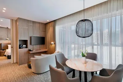 a hotel room with a table and chairs and a television at Courtyard by Marriott Dubai, Al Barsha in Dubai