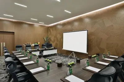 a conference room with a large table and a white screen at Courtyard by Marriott Dubai, Al Barsha in Dubai
