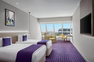 a hotel room with two beds and a flat screen tv at Leva Hotel and Suites, Opposite Downtown in Dubai
