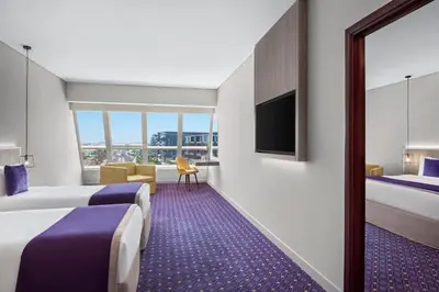 a hotel room with two beds and a tv at Leva Hotel and Suites, Opposite Downtown in Dubai