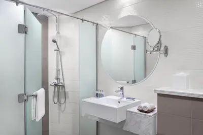 a white bathroom with a sink and a mirror at Leva Hotel and Suites, Opposite Downtown in Dubai
