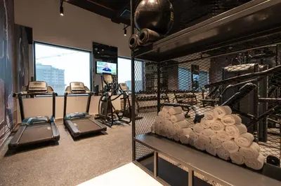 a gym with several treadying machines in a room at Studio One Hotel in Dubai
