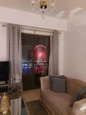 a living room with a couch and a ferris wheel at Luxury Casa - Marvel Sea View Apartment JBR Beach 2BR in Dubai