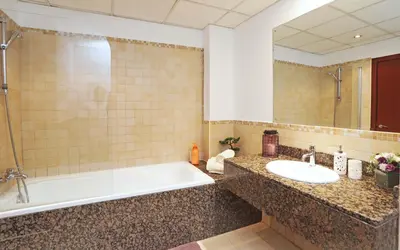 a bathroom with a tub and a sink and a mirror at Luxury Casa - Marvel Sea View Apartment JBR Beach 2BR in Dubai