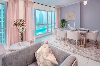 a living room with a couch and a dining room table at Ultimate Stay 2BR: Burj Khalifa and fountain view in Dubai
