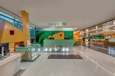 a lobby of a shopping mall with a green wall at Al Khoory Executive Hotel, Al Wasl in Dubai