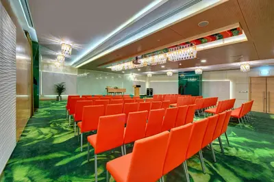 a conference room with orange chairs and a table at Al Khoory Executive Hotel, Al Wasl in Dubai