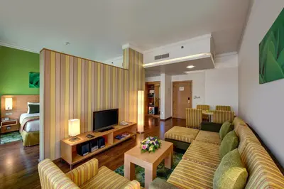 a living room with a couch and a television at Al Khoory Executive Hotel, Al Wasl in Dubai