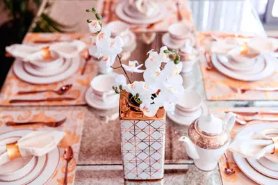 a table topped with white plates and bowls and flowers at Elite Royal Apartment - Burj Residences T5 | VIP in Dubai
