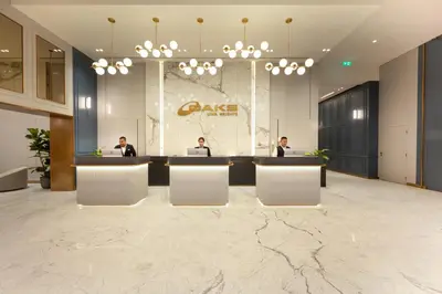 a lobby with three people sitting at a desk at Oaks Liwa Heights Hotel Suites in Dubai