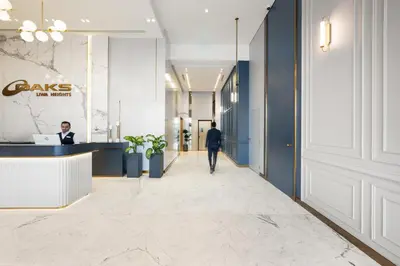 a man walking down a corridor in a office lobby at Oaks Liwa Heights Hotel Suites in Dubai