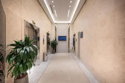 an empty hallway in a hospital with a potted plant at Oaks Liwa Heights Hotel Suites in Dubai