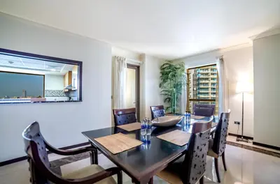 a dining room with a table and chairs at Royal Beach Residence in Dubai