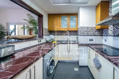 a kitchen with marble counter tops and appliances at Royal Beach Residence in Dubai