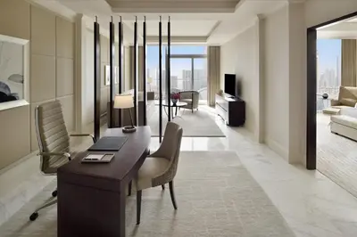 a living room with a desk and chairs and a couch at Address Dubai Mall in Dubai