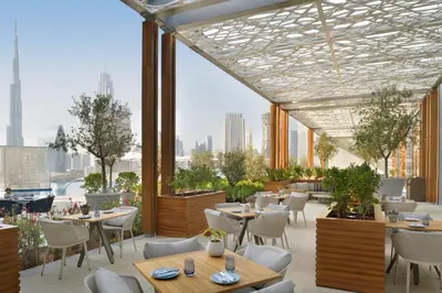 a restaurant with tables and chairs and a view of the city at Address Dubai Mall in Dubai