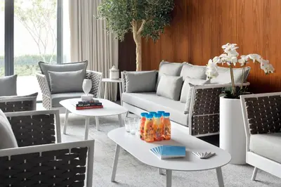 a living room with couches and tables at Vida Emirates Hills in Dubai