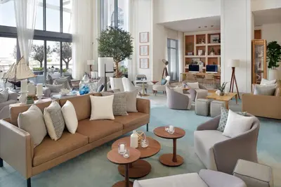 a living room with a couch and chairs and tables at Vida Creek Harbour in Dubai
