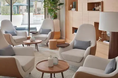 a waiting room with white chairs and tables at Vida Creek Harbour in Dubai