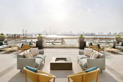 a patio with couches and chairs on a roof at Vida Creek Harbour in Dubai