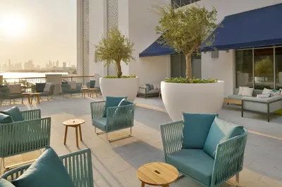 a patio with chairs and tables and trees at Vida Creek Harbour in Dubai