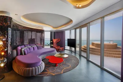 a living room with purple furniture and a view of the ocean at W Dubai - The Palm in Dubai