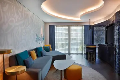 a living room with a blue couch and a tv at W Dubai - The Palm in Dubai