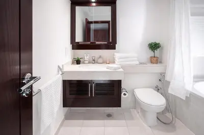 a bathroom with a toilet and a sink and a mirror at Elite Royal Apartment | Burj Residences Tower 5 | Gold in Dubai