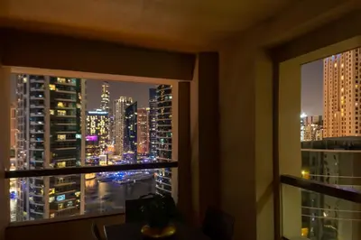 a view of a city at night from a window at SUHA JBR Hotel Apartments in Dubai
