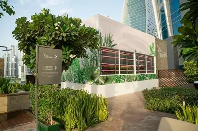 a sign in front of a building with plants at JW Marriott Marquis Hotel Dubai in Dubai