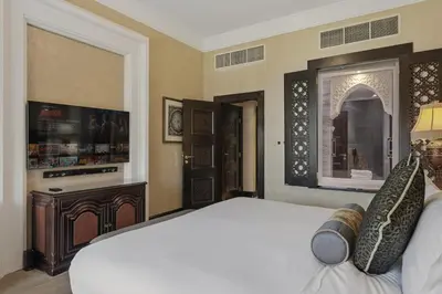 a bedroom with a large bed and a fireplace at Zabeel Saray Royal Residences Lagoon Villa in Dubai