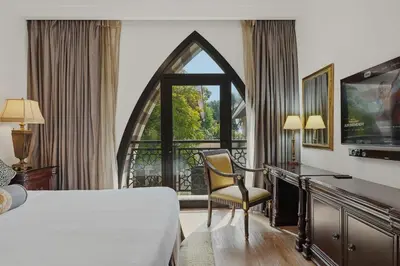 a bedroom with a bed and a desk and a window at Zabeel Saray Royal Residences Lagoon Villa in Dubai