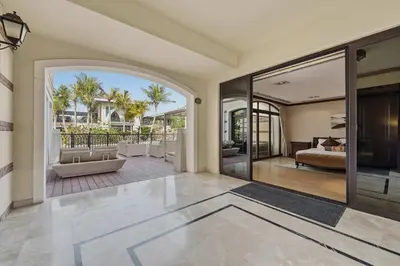 an open living room with a bed and sliding glass doors at Zabeel Saray Royal Residences Lagoon Villa in Dubai