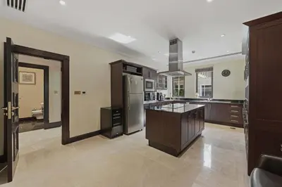 a large kitchen with a refrigerator and a counter at Zabeel Saray Royal Residences Lagoon Villa in Dubai