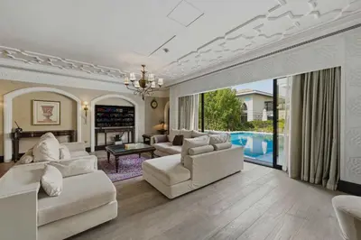 a living room with white furniture and a pool at Zabeel Saray Royal Residences Lagoon Villa in Dubai