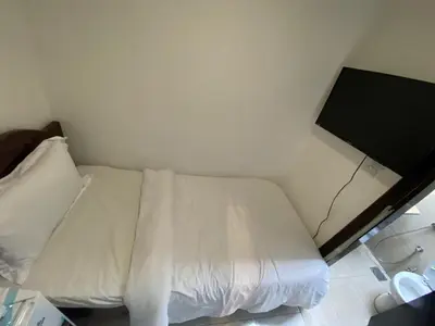 a white bed in a room with a wall at Budget Rooms With Private Bathroom for 'girls' only in Dubai, Marina in Dubai