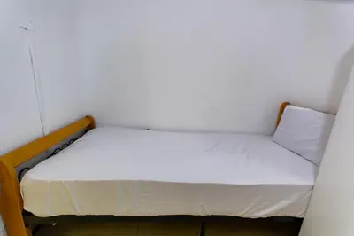 a small bed in a small room with white walls at Budget Rooms With Private Bathroom for 'girls' only in Dubai, Marina in Dubai