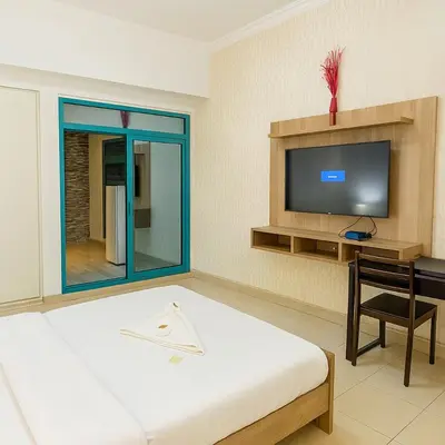 a bedroom with a bed and a desk and a tv at Classy Studios for Ladies in Dubai, Marina فتيات فقط in Dubai
