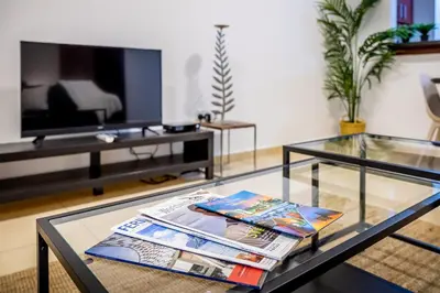 a living room with a glass table and a tv at Big Studio in Rimal at The Beach JBR in Dubai